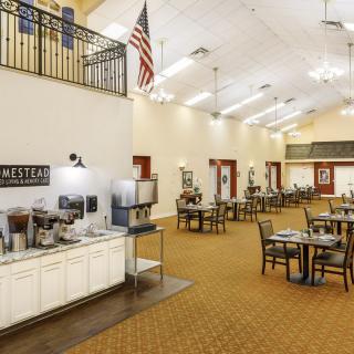 A spacious dining area with multiple tables and a beverage station.