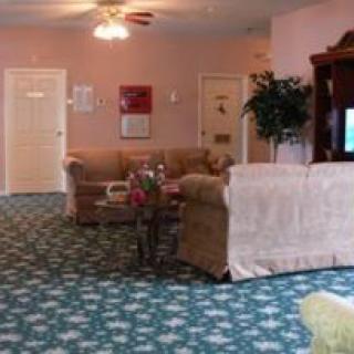 A cozy living room with a sofa, patterned carpet, and a television.