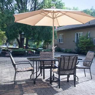 A sunny patio with outdoor furniture including a table, chairs, and a large umbrella.