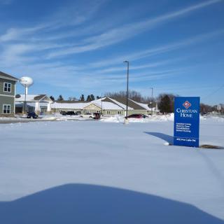 A serene winter scene featuring a snowy landscape with buildings under a clear blue sky.