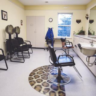 An interior view of a hair salon with empty chairs and styling stations.