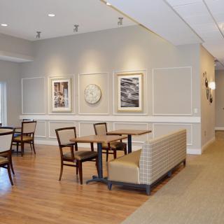 A cozy dining area with wooden flooring and artwork on the walls.