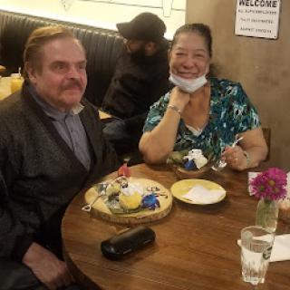 A cheerful couple enjoying dessert at a cozy restaurant.