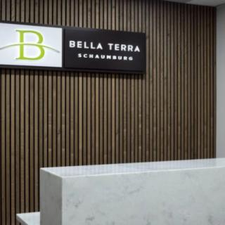 A modern reception area featuring a marble desk and wall signage for Bella Terra.