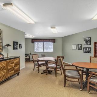 A cozy room with tables, chairs, and wall decor.