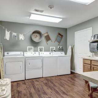 A clean and organized laundry room with washers, dryers, and decorative elements.