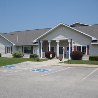 A single-story building with a front entrance surrounded by accessible parking spaces.