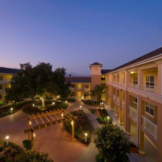 A beautifully lit courtyard surrounded by residential buildings at dusk.