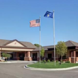 A building with multiple flags flying outside, including the American flag, under a clear blue sky.