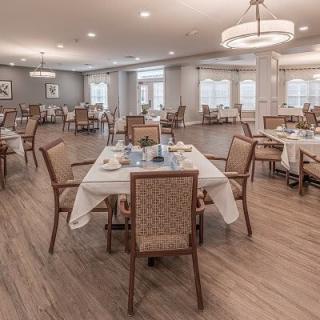 An elegant dining room with neatly arranged tables and chairs, featuring a spacious and well-lit interior.
