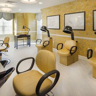 A modern beauty salon with stylish chairs and hair dryers.