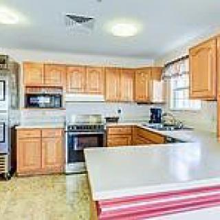 A spacious kitchen with wooden cabinets and modern appliances.