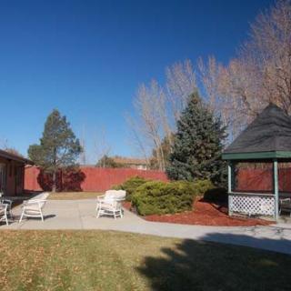A peaceful backyard with a gazebo and outdoor seating under a clear blue sky.