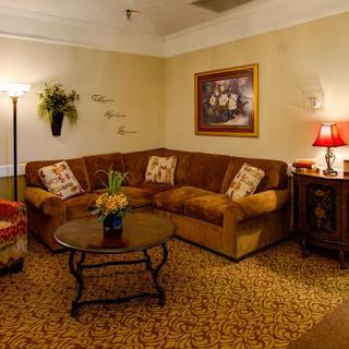 A cozy living room with a corner sofa, coffee table, and warm lighting.