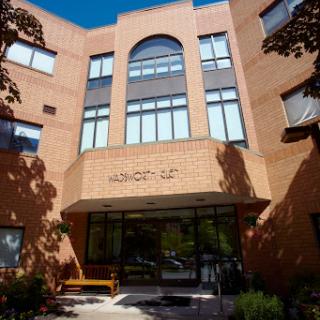 A modern brick building featuring large windows and an inviting entrance.