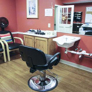 A cozy salon featuring a barber chair, sink, and additional seating.