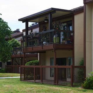 A residential apartment building with balconies overlooking a grassy area.