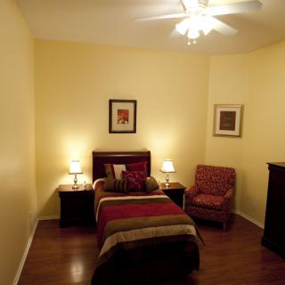 Cozy bedroom with a single bed and warm lighting.
