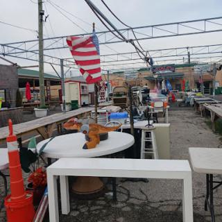 An empty outdoor market featuring tables and an American flag, creating a unique commercial atmosphere.
