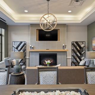 A modern living room featuring a cozy fireplace, elegant chandelier, and stylish furniture.