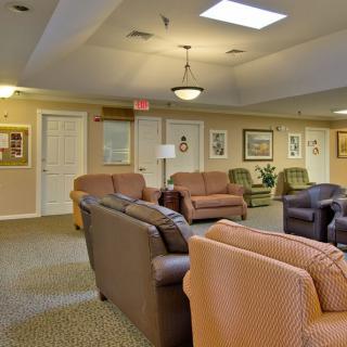 A cozy living room with several sofas and warm lighting.
