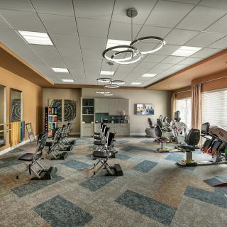 A modern gym with various exercise equipment and a spacious layout.