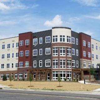 A modern apartment building with a unique design and multiple floors.
