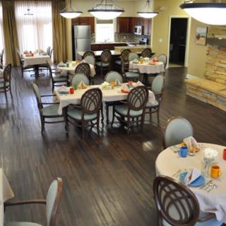 A well-arranged dining area with set tables and chairs, featuring a warm and inviting atmosphere.