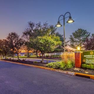 A peaceful park entrance illuminated by street lamps during the evening.