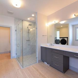 A modern bathroom featuring a glass-enclosed shower and a sleek vanity with a large mirror.
