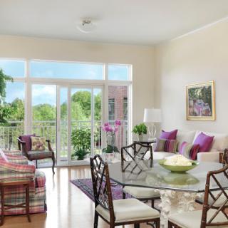 A bright and inviting living room with modern furniture, a dining table, and vibrant plants, creating a cozy atmosphere.