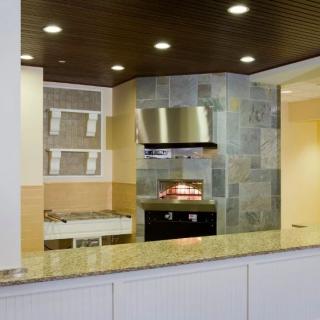 Modern kitchen with a stone backsplash, built-in oven, and sleek countertop.