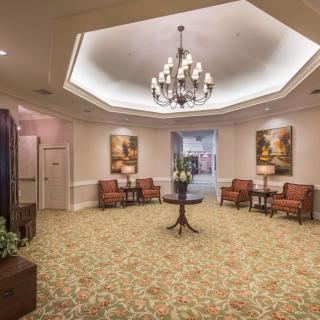 A well-decorated lobby with a chandelier, seating area, and elegant decor.