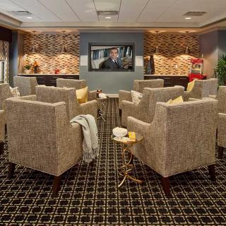 A comfortable lounge area with upholstered chairs facing a television.