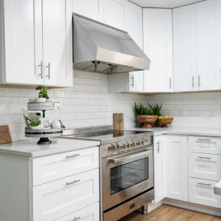 A modern kitchen with white cabinets and stainless steel appliances.