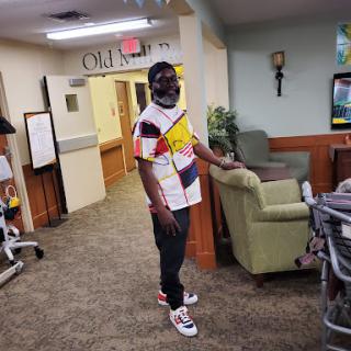 A person stands in a cozy lounge area, wearing a vibrant casual outfit.