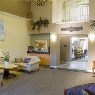 A cozy and elegantly designed living room with comfortable sofas, a chandelier, and tasteful decorations.