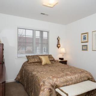 A cozy bedroom with a bed, nightstand, and decorative elements.