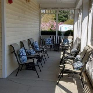 A cozy porch with several chairs adorned with floral pillows, perfect for relaxation.