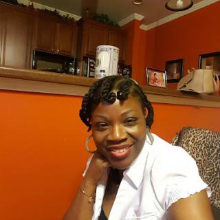 A cheerful woman poses for a photo in a cozy indoor setting.