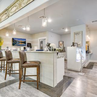 A modern kitchen interior with bar stools and elegant lighting.