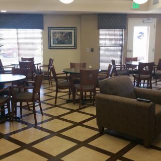 A cozy cafe lounge with tables and chairs arranged on a patterned floor.