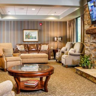 A cozy living room with comfortable seating, a coffee table, and a television mounted on the wall.
