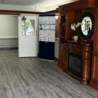 A cozy interior with a wooden fireplace and mirror, complemented by stylish flooring.