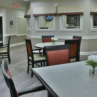 A clean and minimalist dining area with neatly arranged tables and chairs.