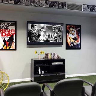 A home theater setup with vintage movie posters on the wall and a TV screen displaying a black and white film.