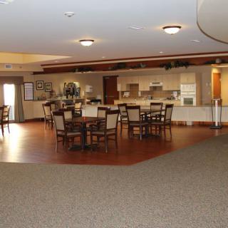 A spacious interior dining area with tables and chairs, adjoining a kitchenette.