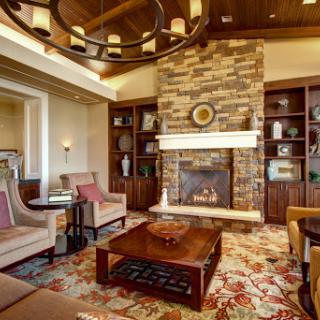 A beautifully designed living room featuring a stone fireplace, comfortable seating, and elegant decor.