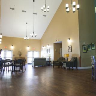 A spacious, well-lit interior room with chandeliers and comfortable seating.