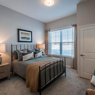 A beautifully designed modern bedroom featuring a queen-sized bed, soft lighting, and ample natural light.